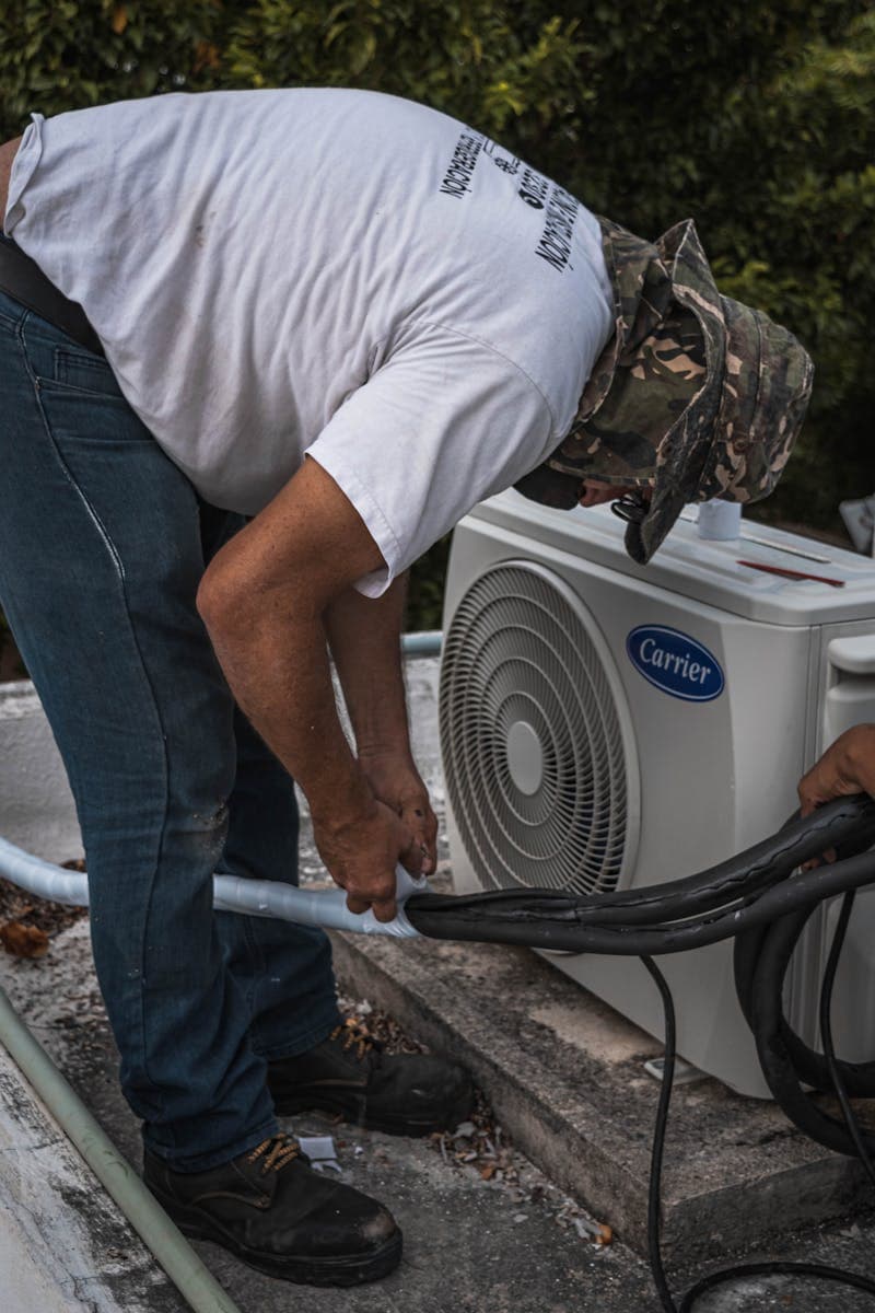 HVAC technician servicing outdoor air conditioning unit